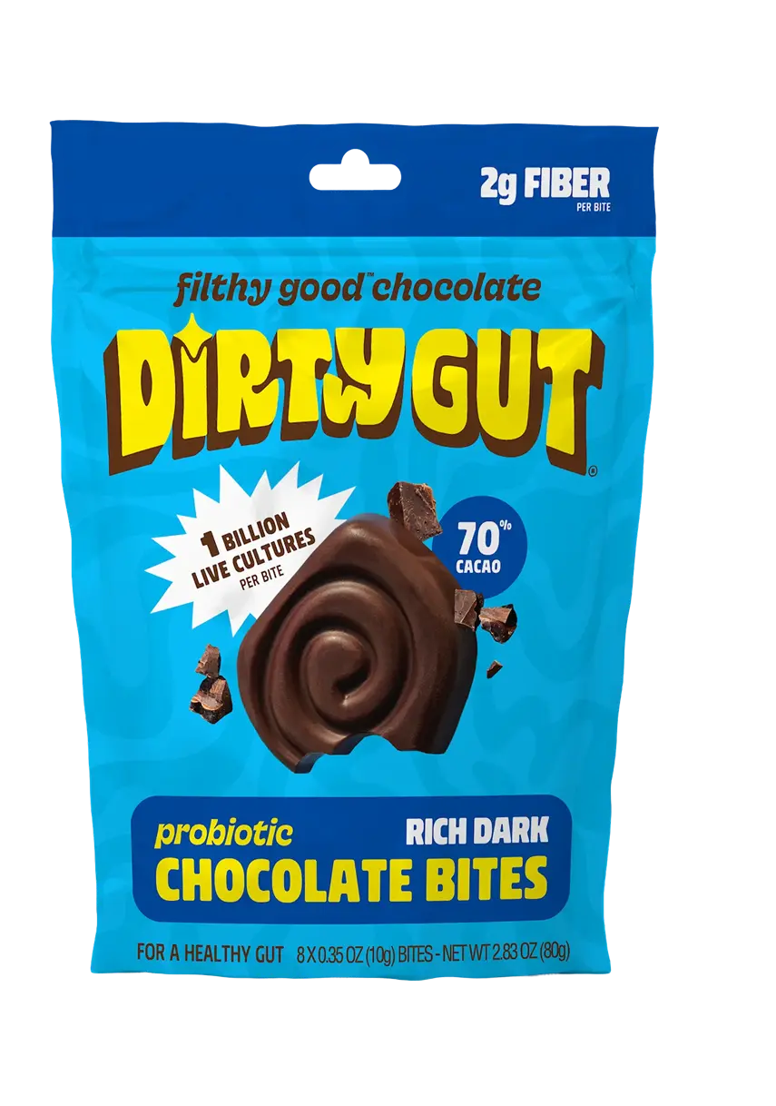 A blue bag of Dirty Gut probiotic rich dark chocolate bites on a solid green background.