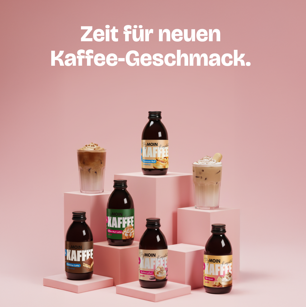 An assortment of Moin Kaffee bottles and two iced coffee drinks on a pink, tiered display.