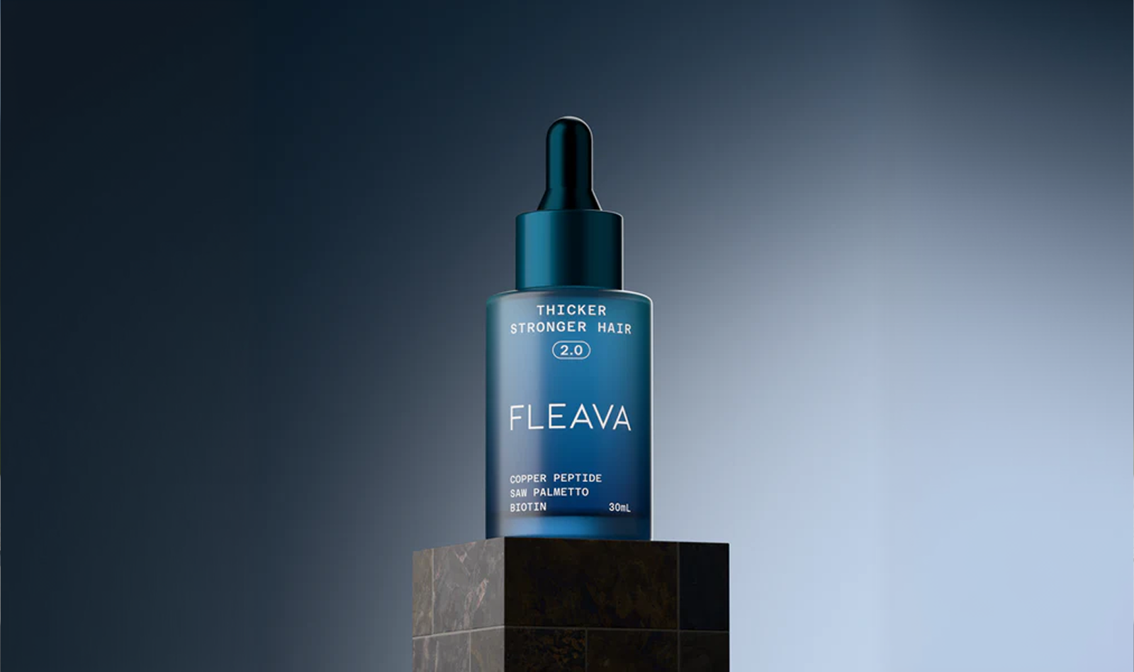 A blue bottle of Fleava hair serum with a dropper top, sitting on a dark stone pedestal.