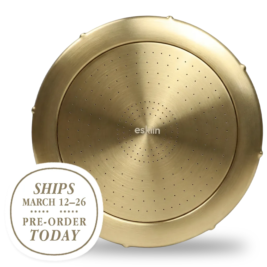 A round, brushed brass Eskin shower head with a pre-order badge on a green background.