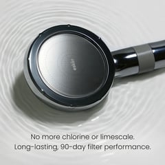 Chrome handheld showerhead resting in water with 90-day filter information