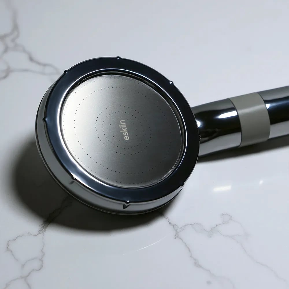 The eskiin Handheld Filtered Showerhead on a marble surface