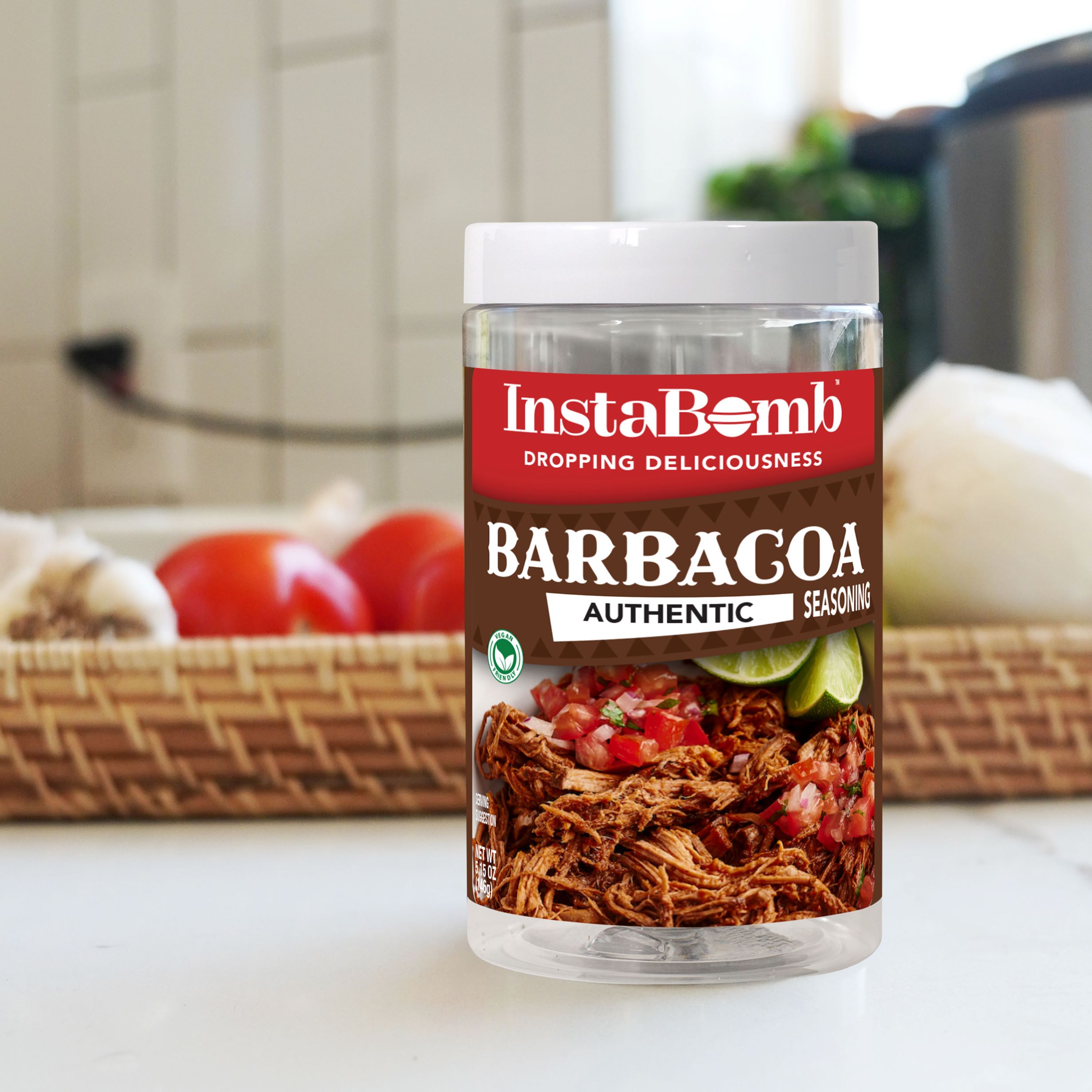 Jar of InstaBomb Barbacoa seasoning with kitchen ingredients in the background.