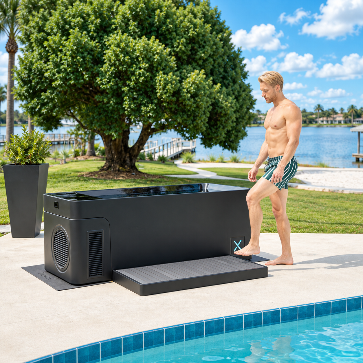 A man in swim trunks prepares to step into a black cold plunge tub next to a pool.