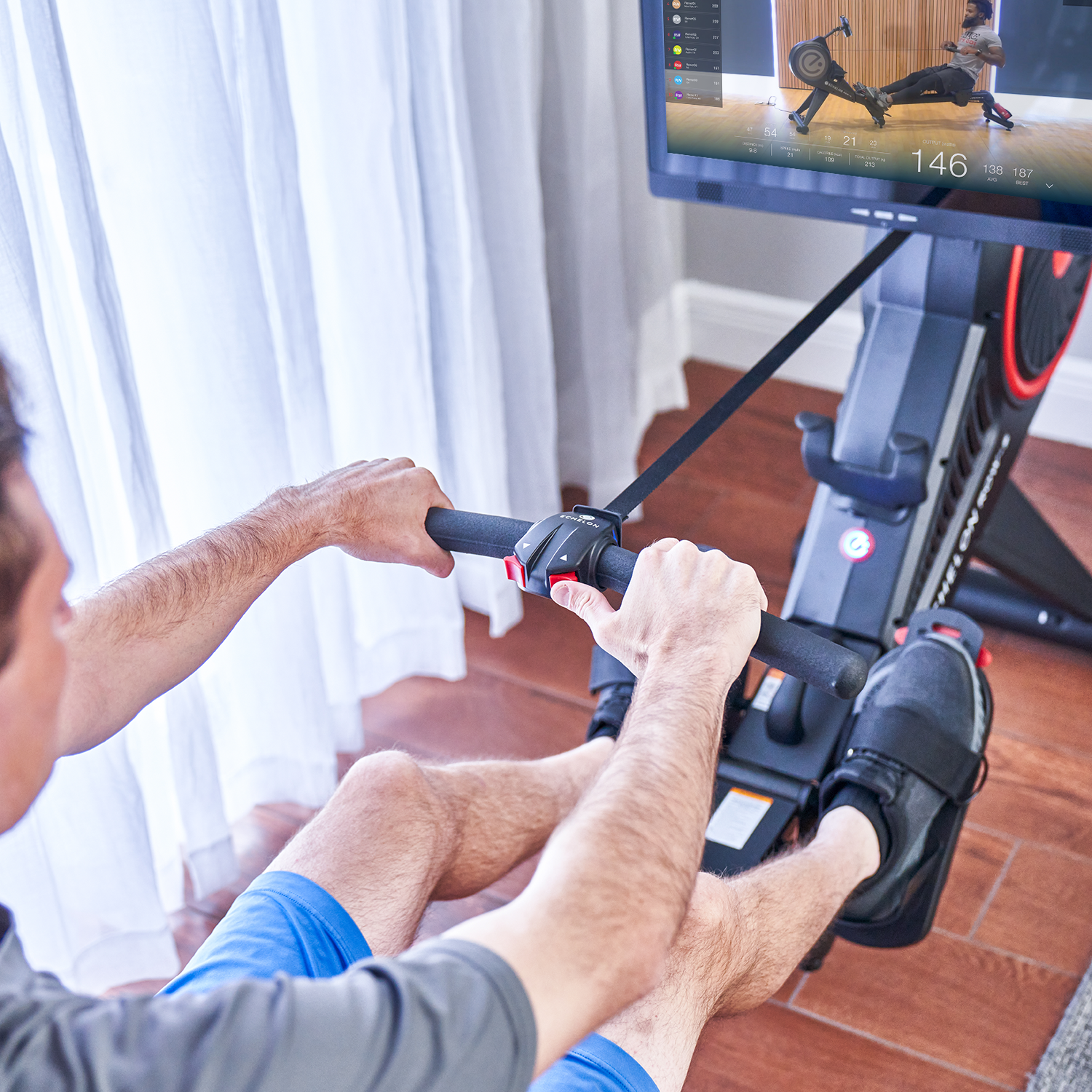 Person using a rowing machine with digital display.