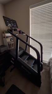 Stair stepper exercise machine next to a window with closed blinds.