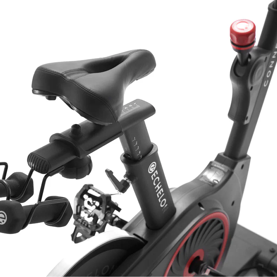 Close-up of a black exercise bike seat and pedals.