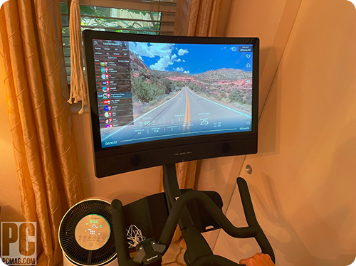 Exercise bike with a screen displaying a scenic road view.