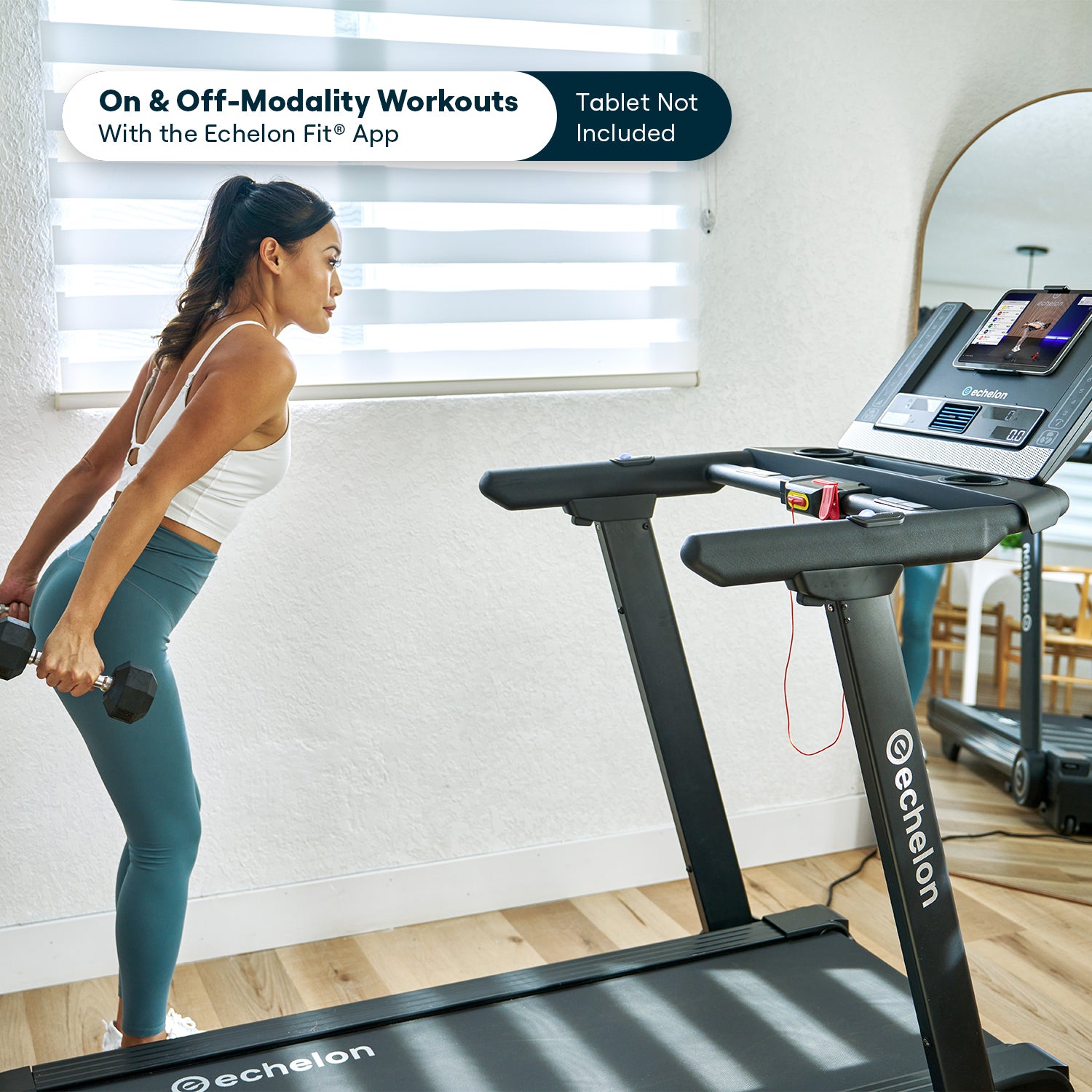 Woman exercising with dumbbells next to a treadmill in a bright room.