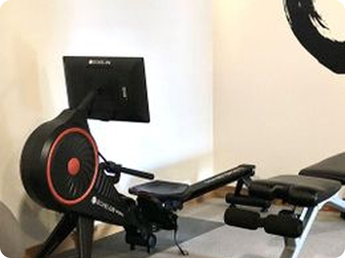 Indoor rowing machine with screen in a room.