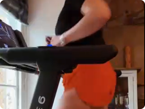 Person running on a treadmill indoors.