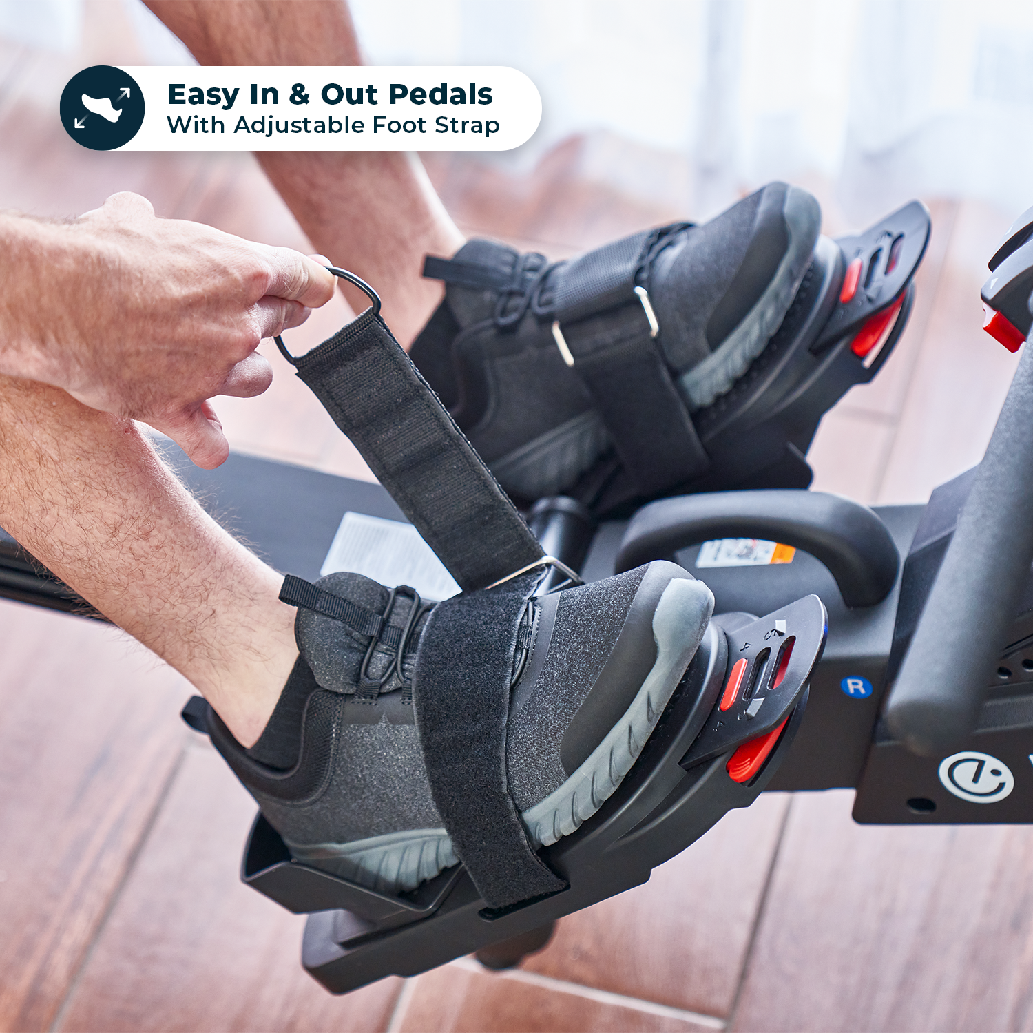 Person adjusting foot strap on exercise bike pedal with black shoes.