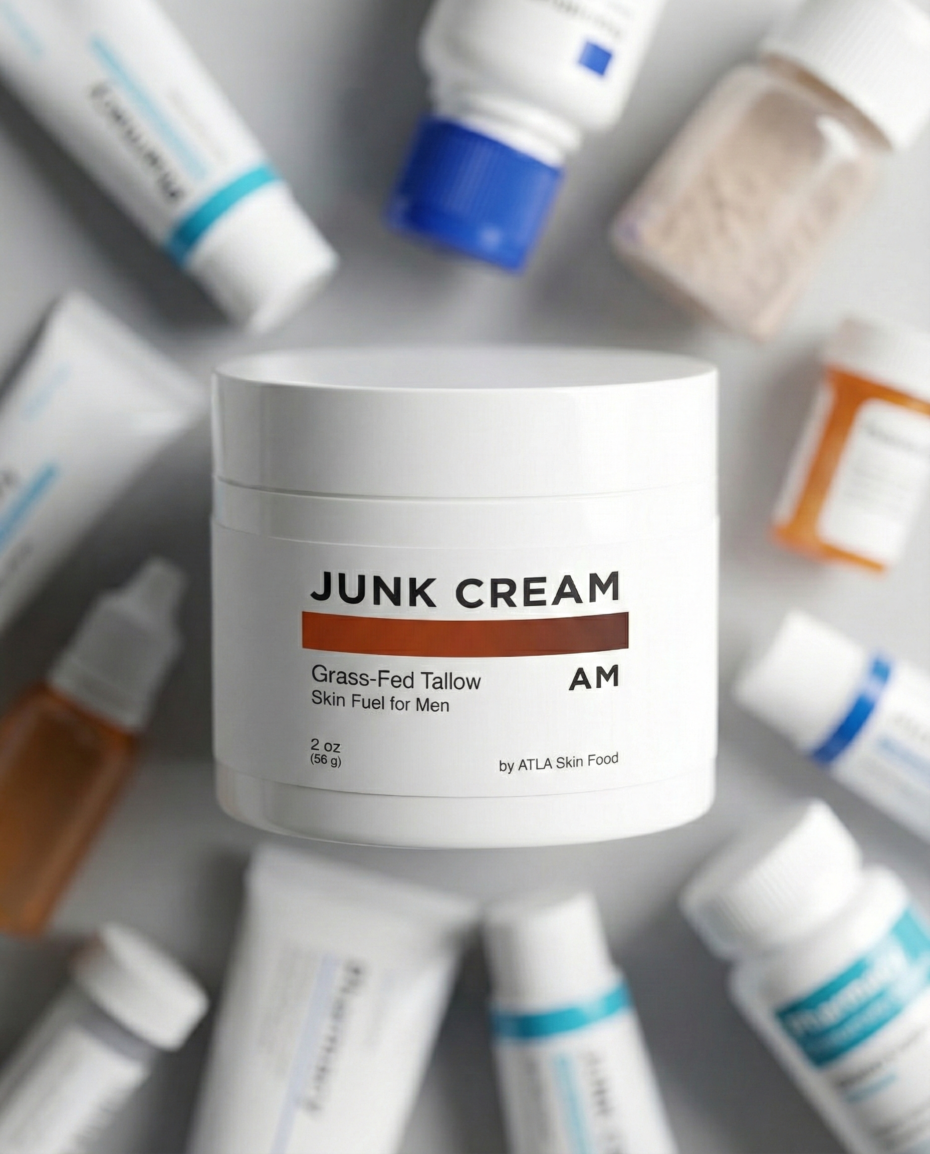 A top-down view of a white jar of Junk Cream surrounded by other blurred skincare products.