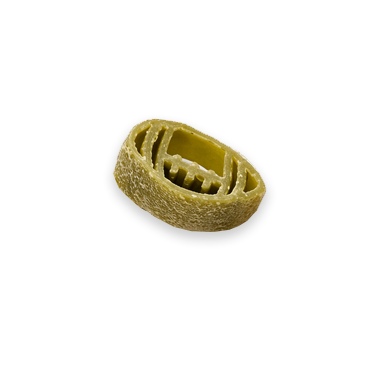 Close-up of an oval, ridged pasta shape with a hollow center on a black background