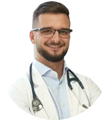 Smiling person with glasses wearing a white coat and stethoscope.