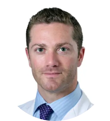 Man in professional attire with short hair and a light beard.