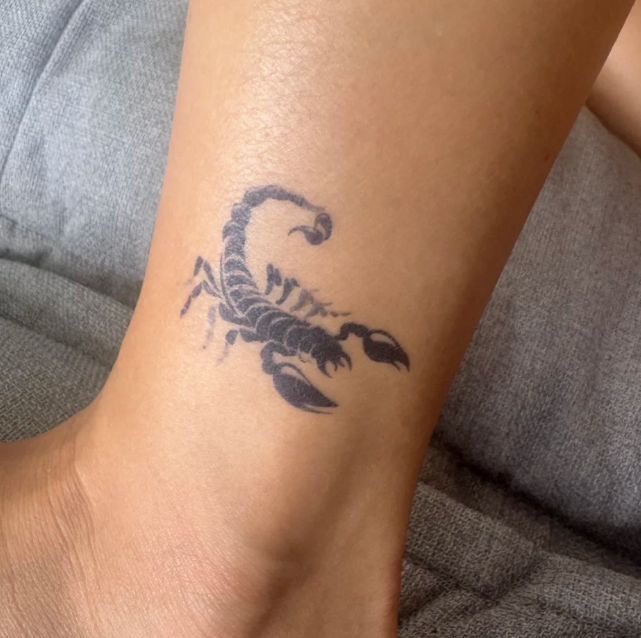 Scorpion tattoo on a person's ankle.