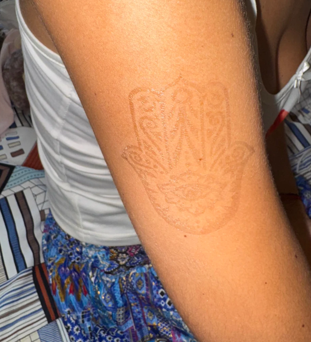 Arm with a henna tattoo of a Hamsa design.