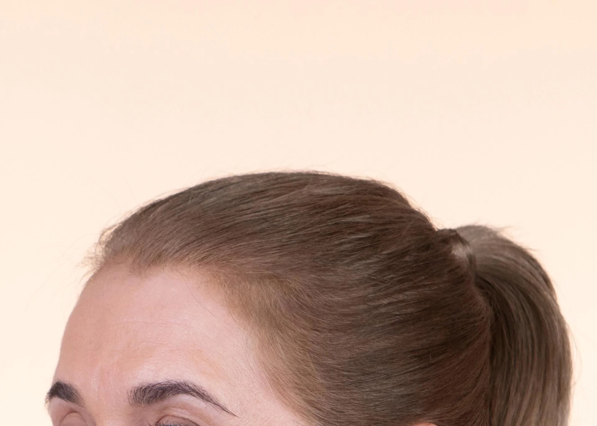 Close-up of a person with brown hair in a ponytail.