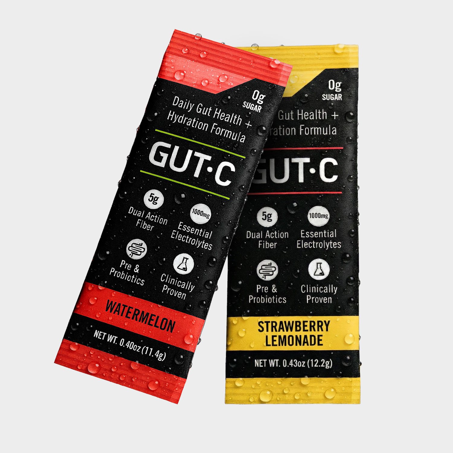 Two single-serving packets of GUT-C drink mix in Watermelon and Strawberry Lemonade flavors, covered in water droplets.