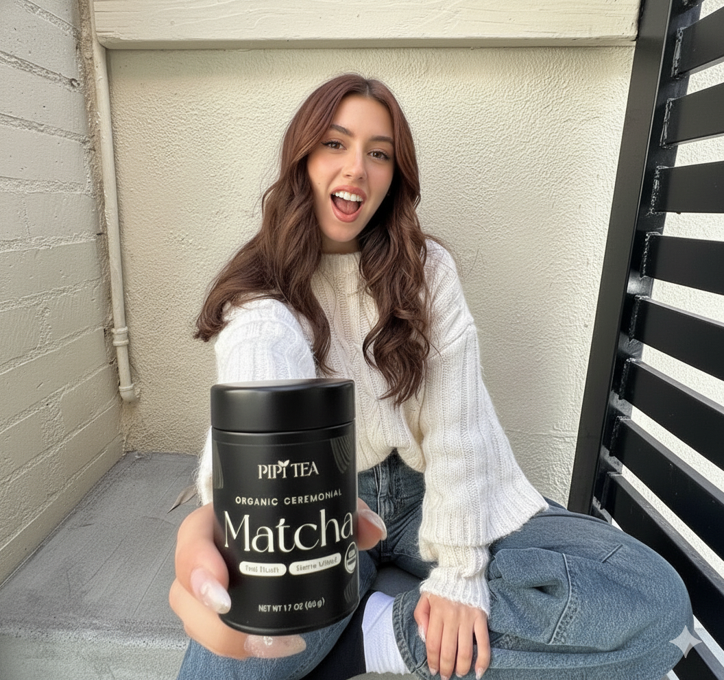 A woman in a white sweater excitedly holds a black canister of Pipi Tea matcha toward the camera.