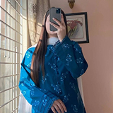 Person in blue outfit taking a mirror selfie indoors.