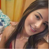 Person smiling in a selfie, with a blurred indoor background.