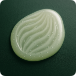 White, textured oval object with wavy lines on a dark green background.