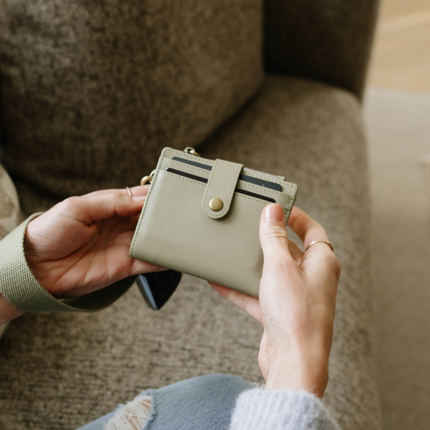 White lotion bottle with a pump next to green plant leaves on a geometric background.