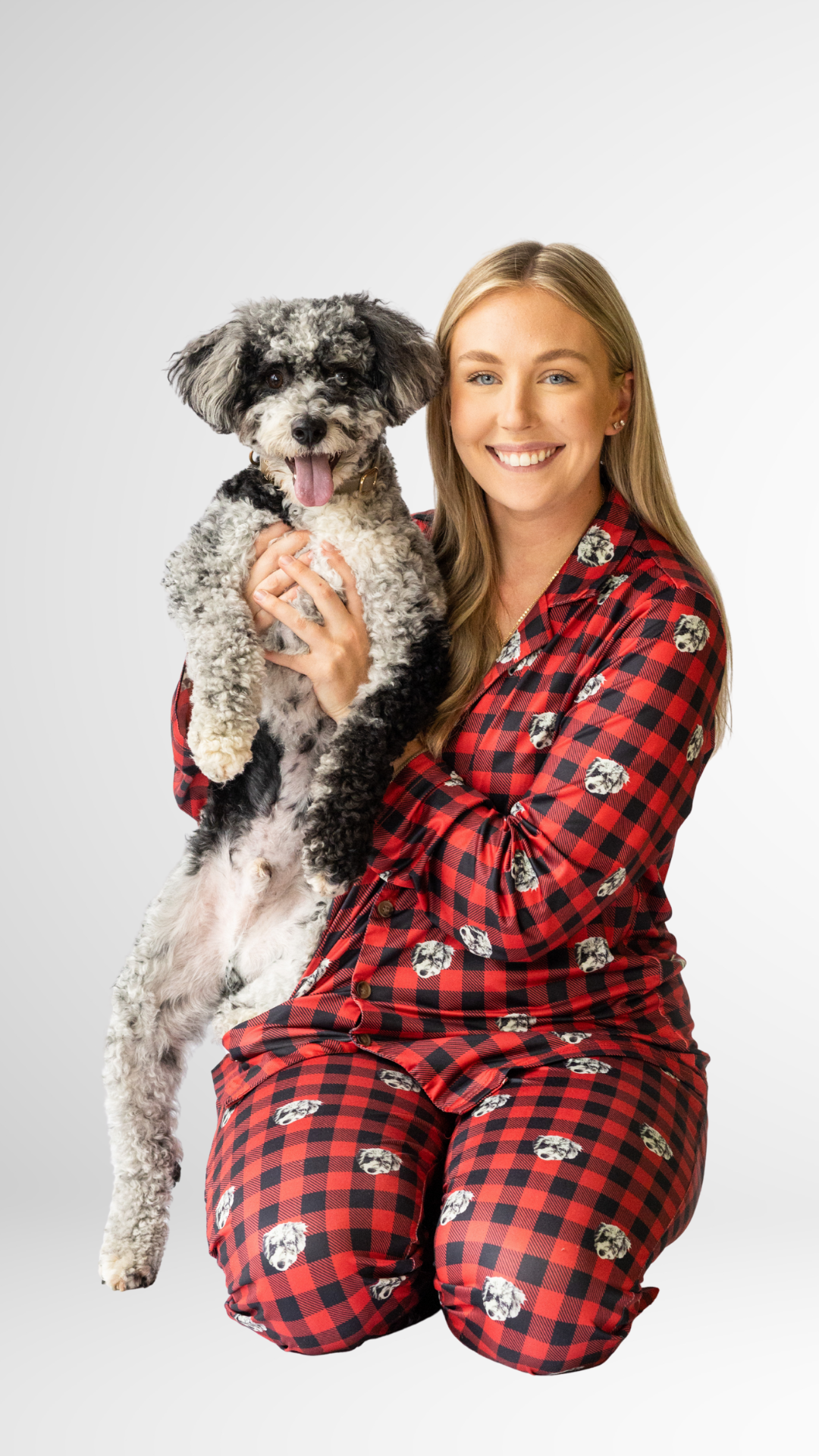 Woman in red plaid pajamas holding her matching dog with custom face print.