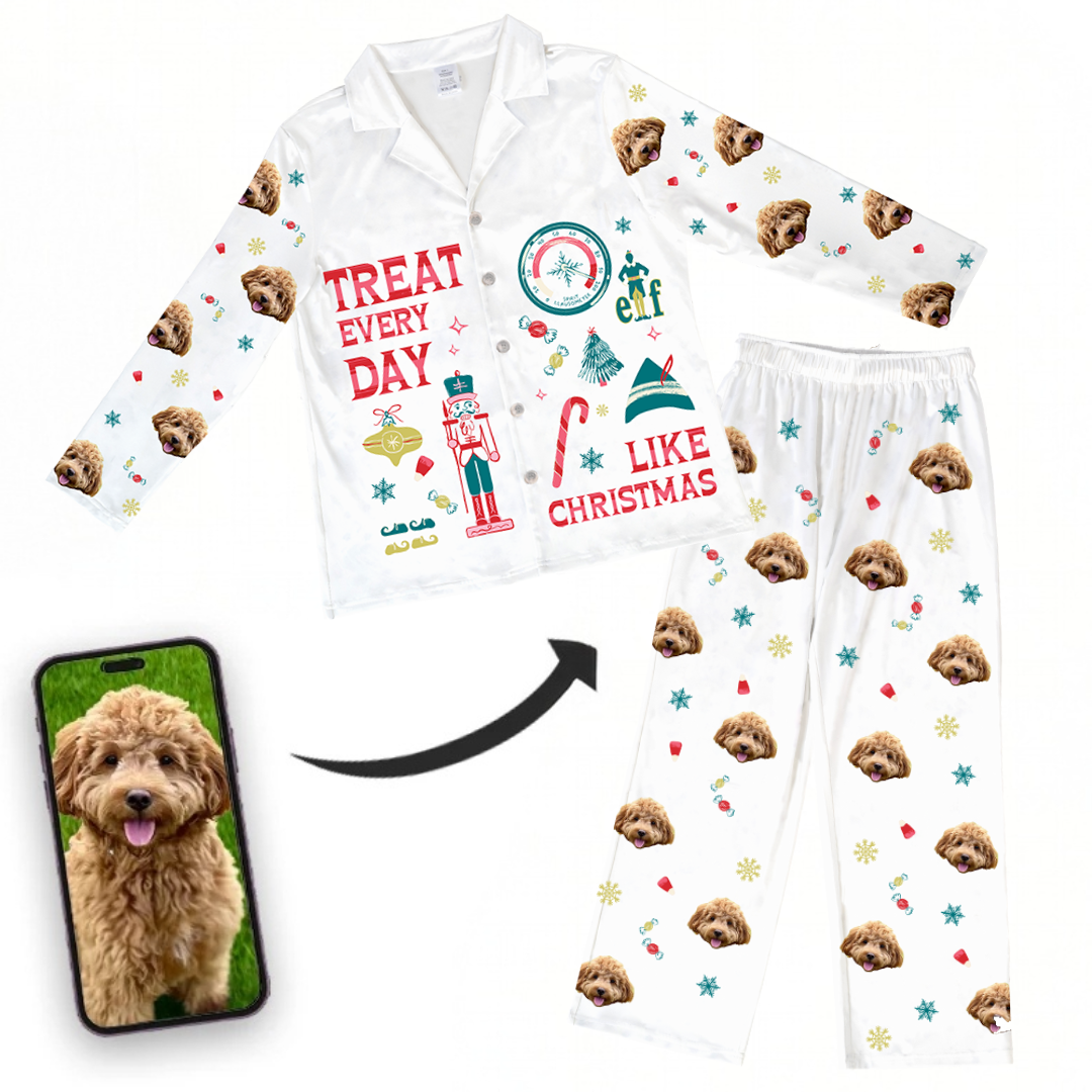 A white pajama set featuring the phrase 'TREAT EVERY DAY LIKE CHRISTMAS' with holiday and Elf-themed graphics. The pajamas are patterned with a repeating print of a black, tan, and white dog's face, along with various candy and snowflake graphics. A full image of the dog is shown below the pajamas.