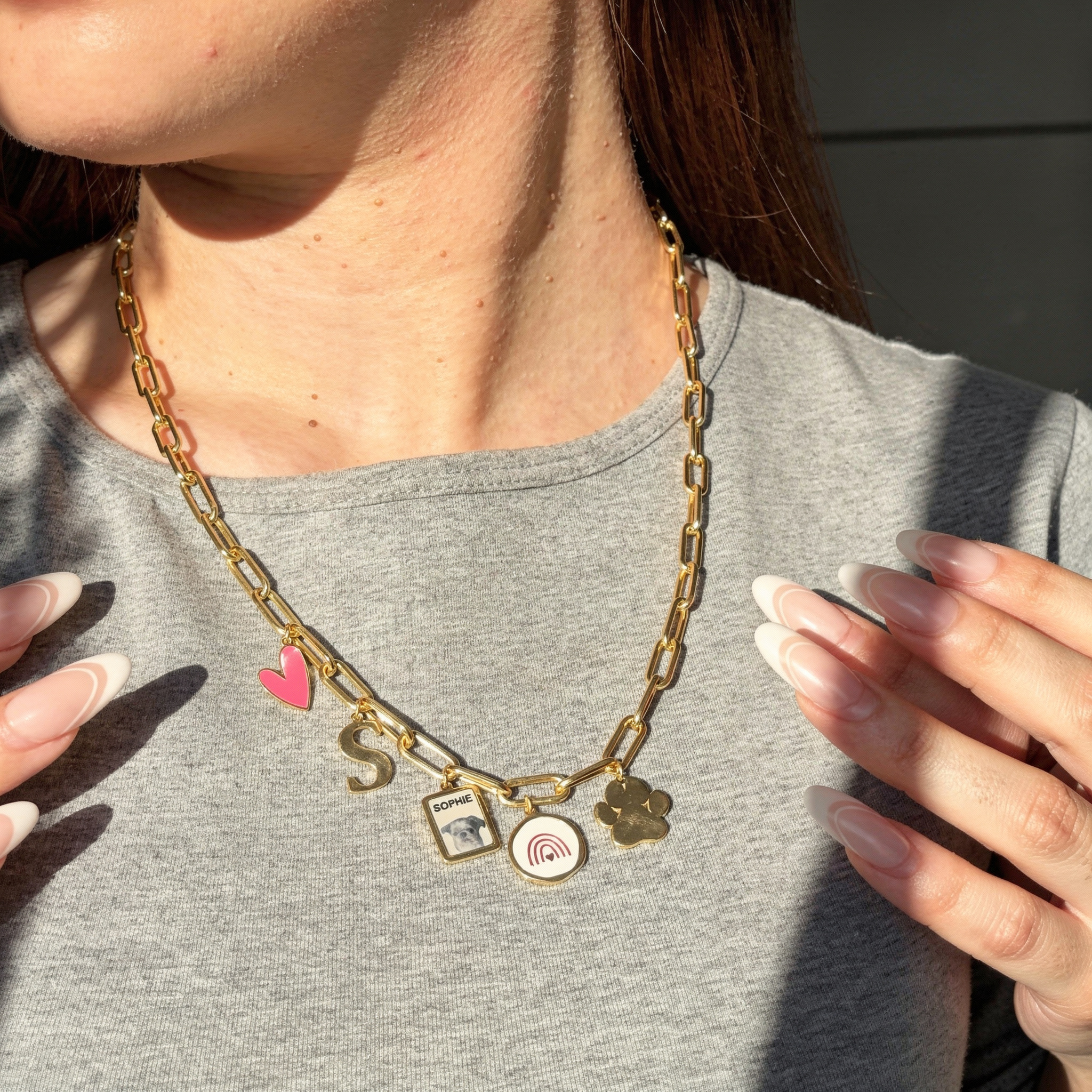 Woman wearing gold chain charm necklace with pink heart, S, Sophie photo, rainbow, paw