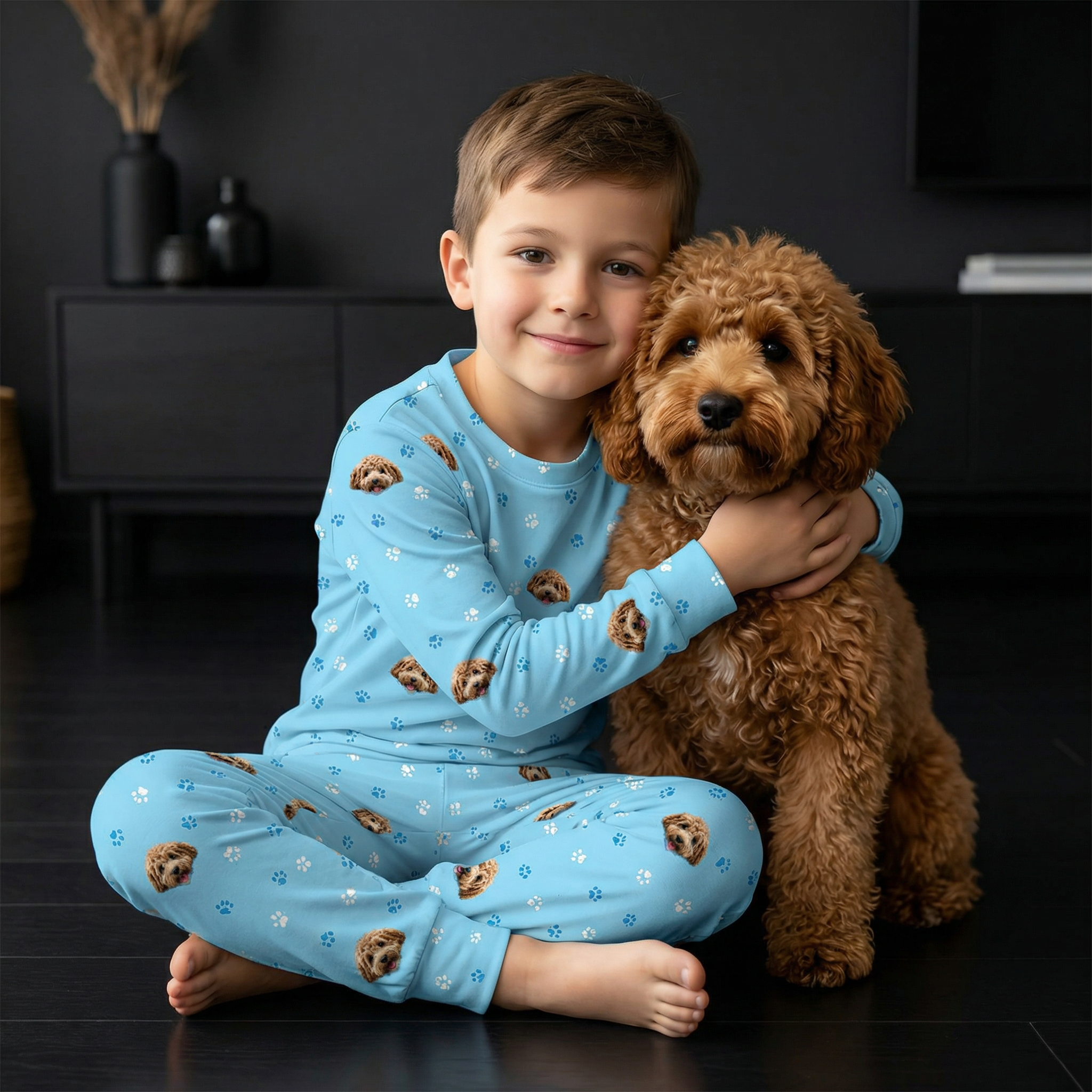 Boy wearing a jogger pajamas next to a dog.