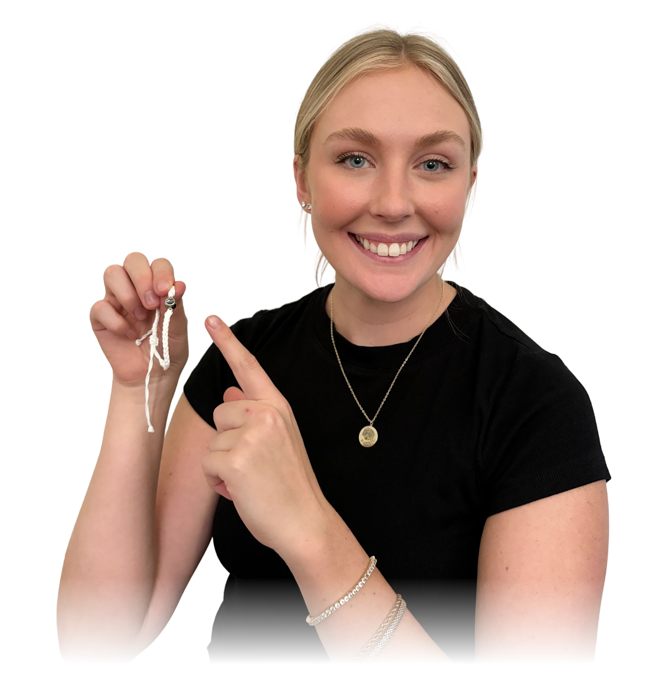 A smiling young blonde woman in a black shirt is seated, pointing to a piece of white bracelet.