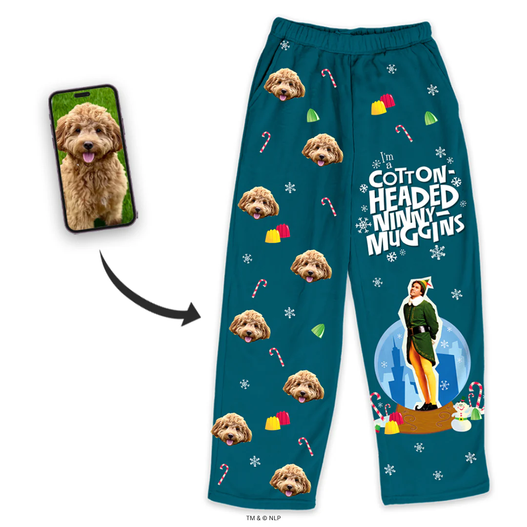 A pair of teal blue pajama pants featuring a graphic of Buddy the Elf and the quote 'I'M A COTTON-HEADED NINNY MUGGINS,' surrounded by snowflakes and candy canes.