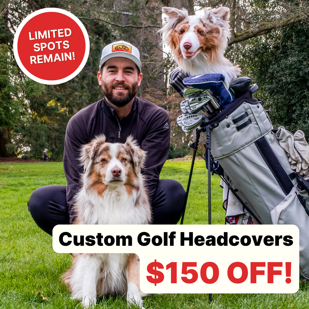 
A man wearing a baseball cap and dark athletic clothing crouches on a grassy golf course, smiling next to a beautiful Australian Shepherd with red merle coloring. Standing to the right is a golf bag containing clubs, with a custom, realistic plush headcover designed to look exactly like the dog's head and neck.