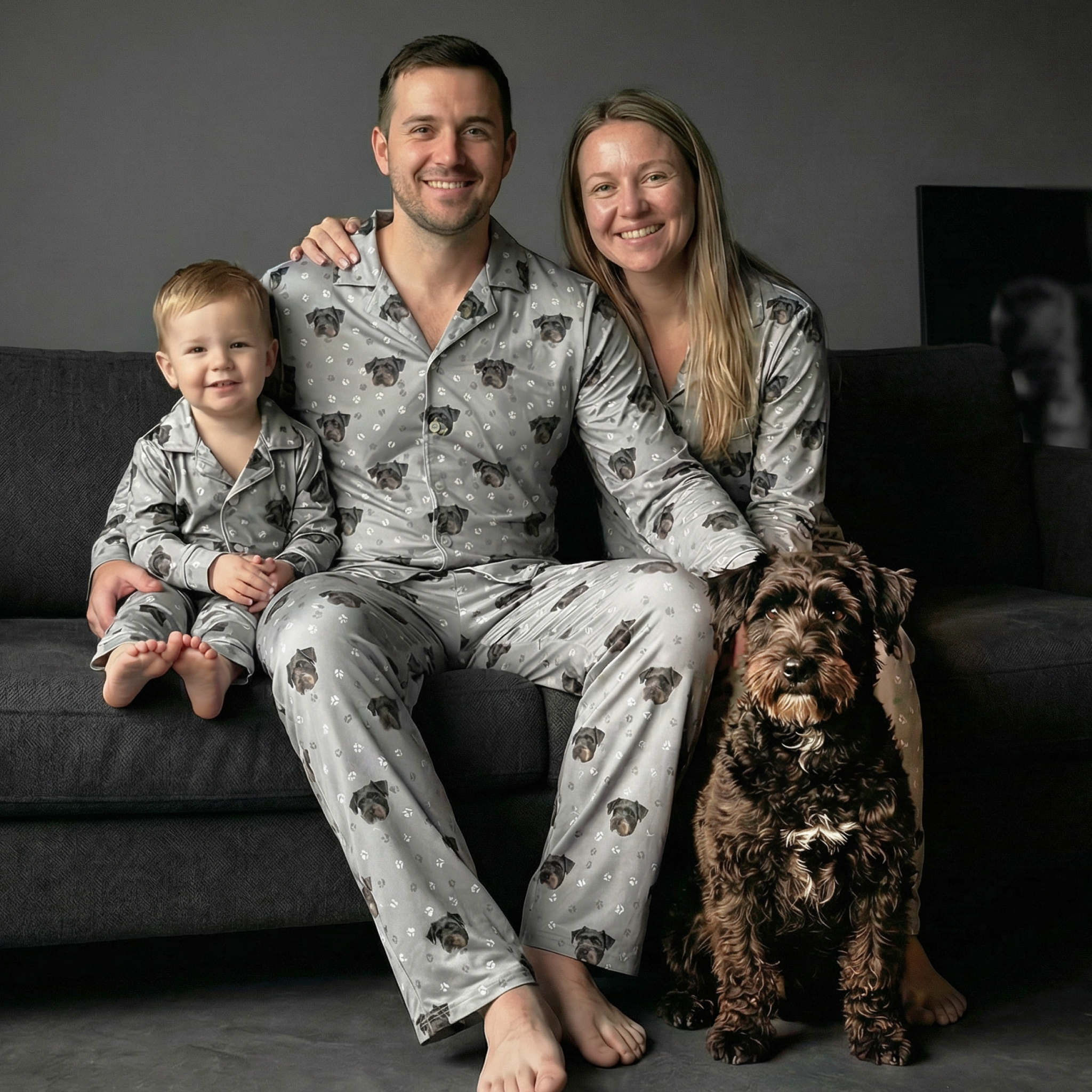 Family wearing gray pajamas with dog faces, their dog is in the picture.