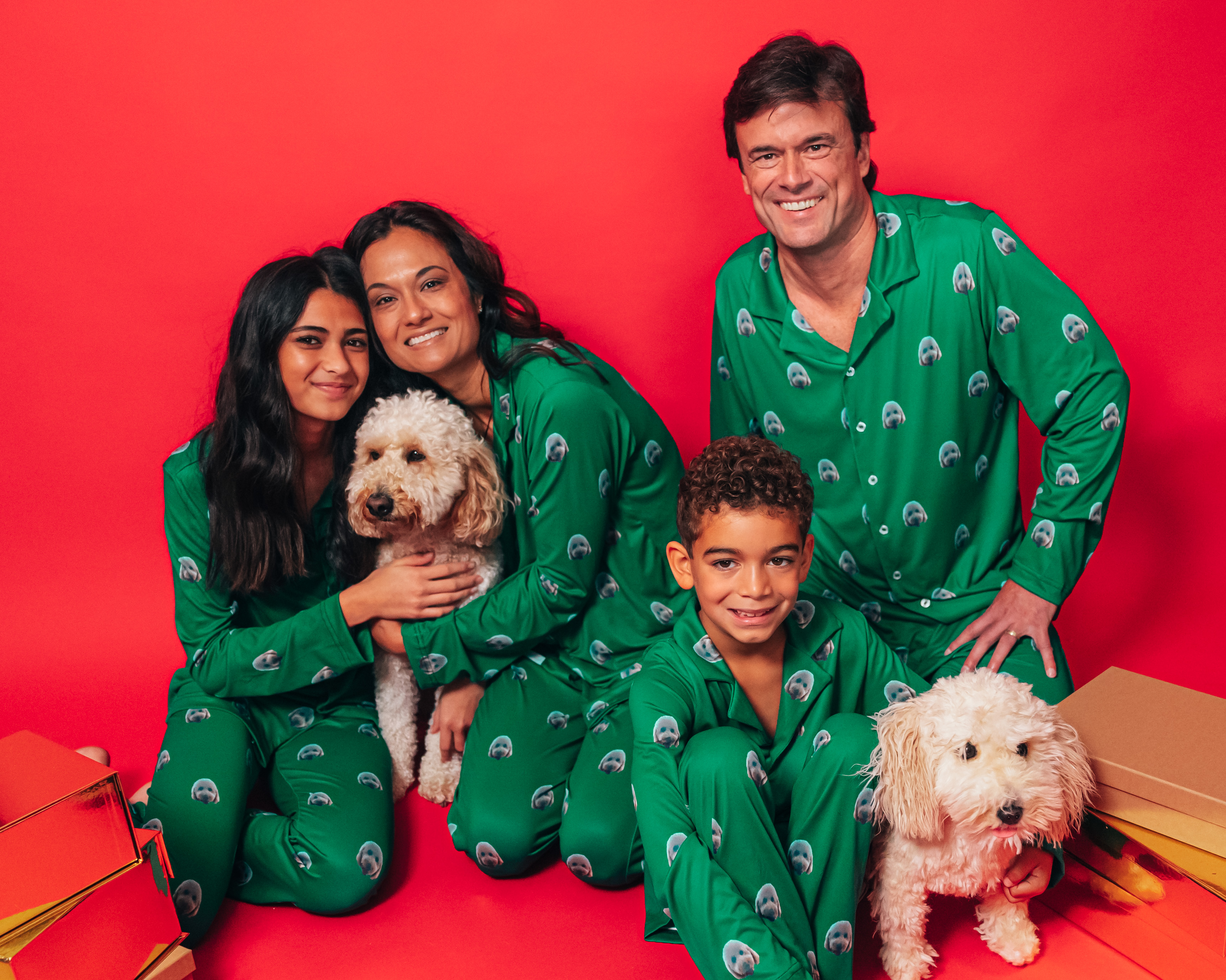 Family of four wearing matching green button down pajamas.