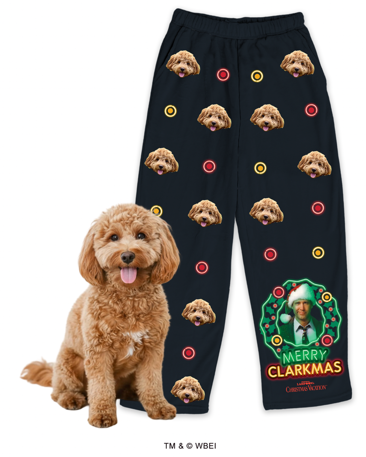 Black pajama pants customized with a repeating design of a fluffy brown Cockapoo's face and red and yellow neon-style circles (like Christmas lights). The lower leg features a large graphic of Clark Griswold in a light-up wreath with the text 'MERRY CLARKMAS.' A real Cockapoo dog sits in the foreground.