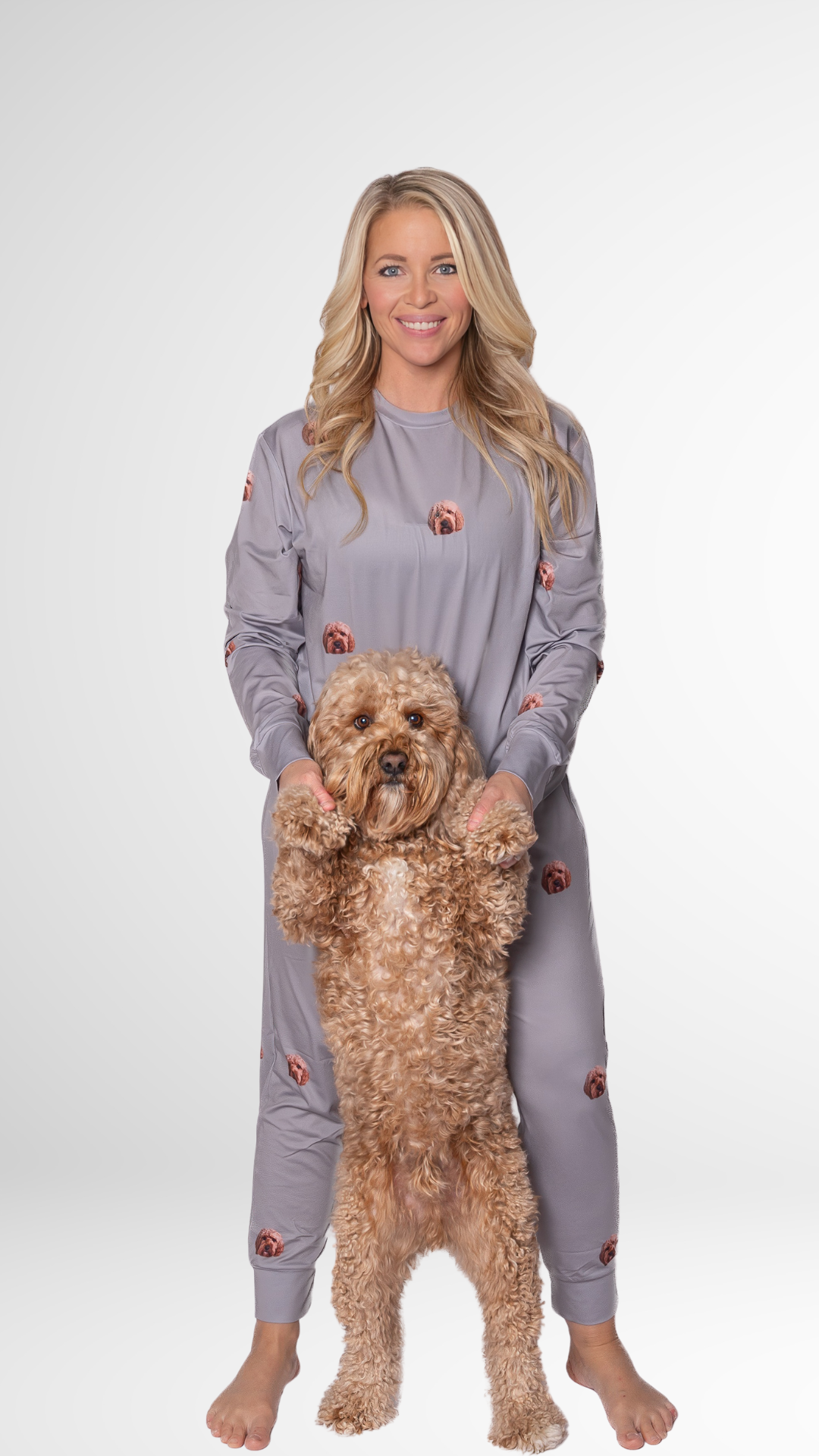 Woman in gray pajamas holding her fluffy dog with matching custom face print.
