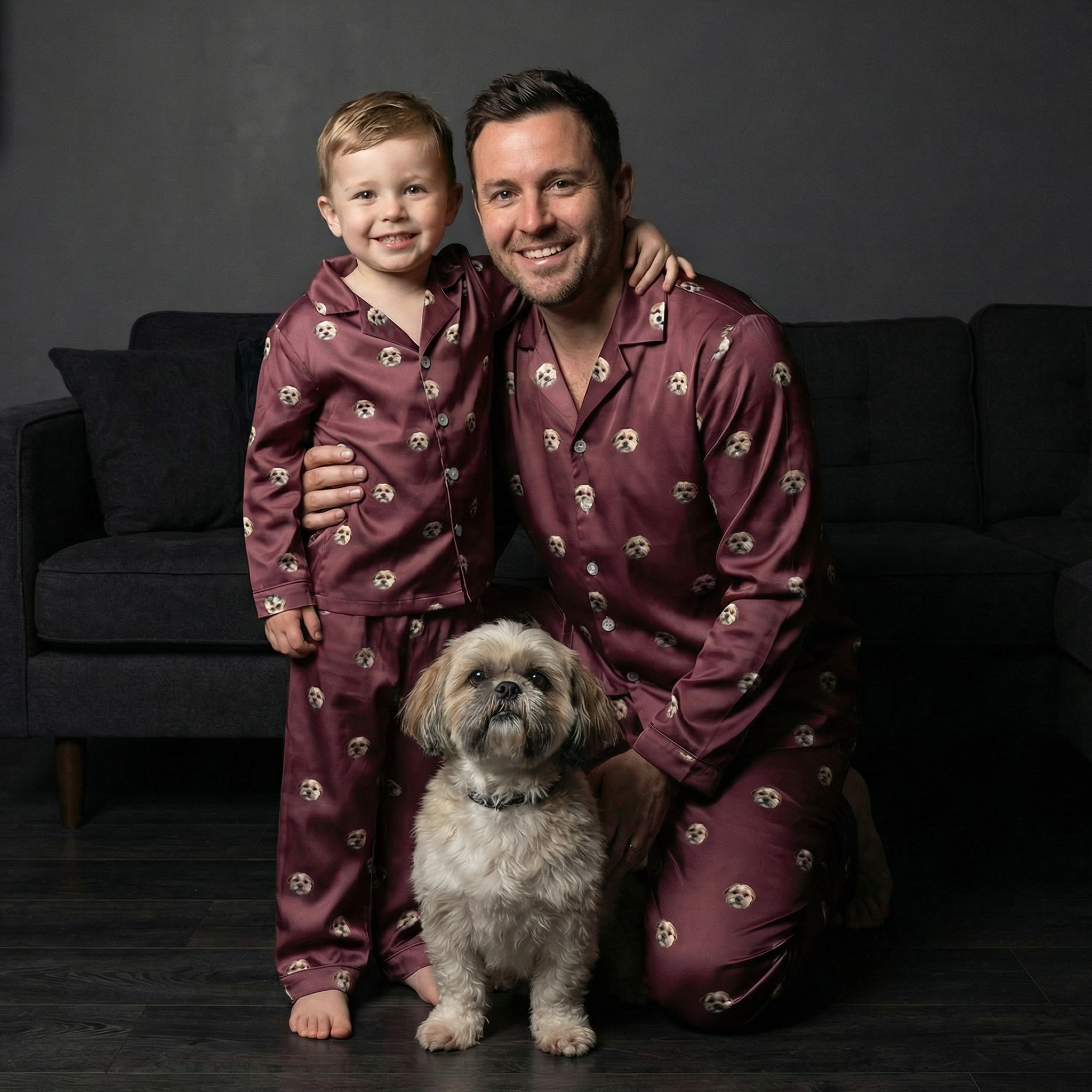 Father and kid in matching brown dog-print button-down pajamas with their dog.
