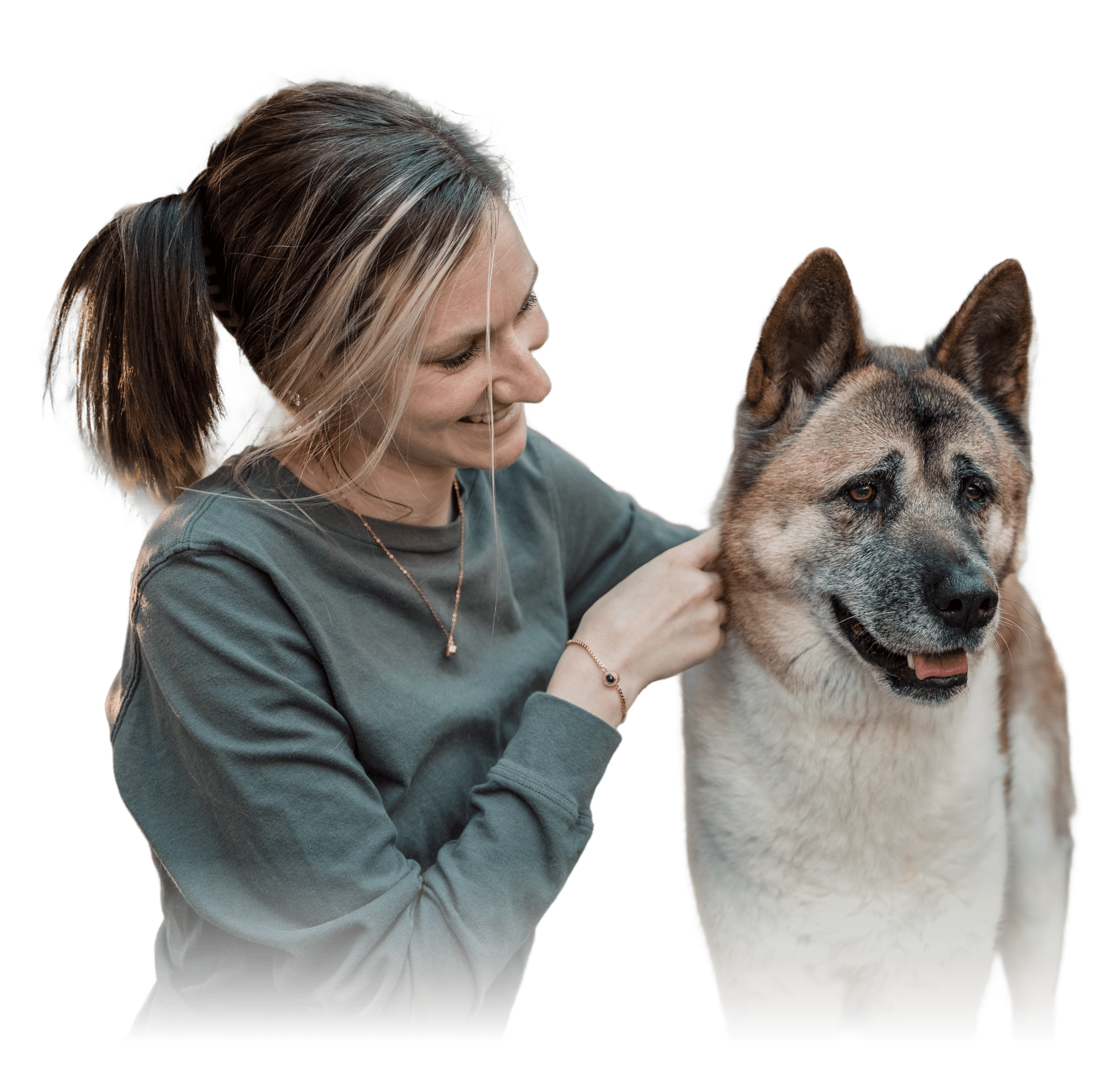 A woman is next to dog, she is wearing a delicate gold necklace and a dark-charm bracelet on her wrist. 