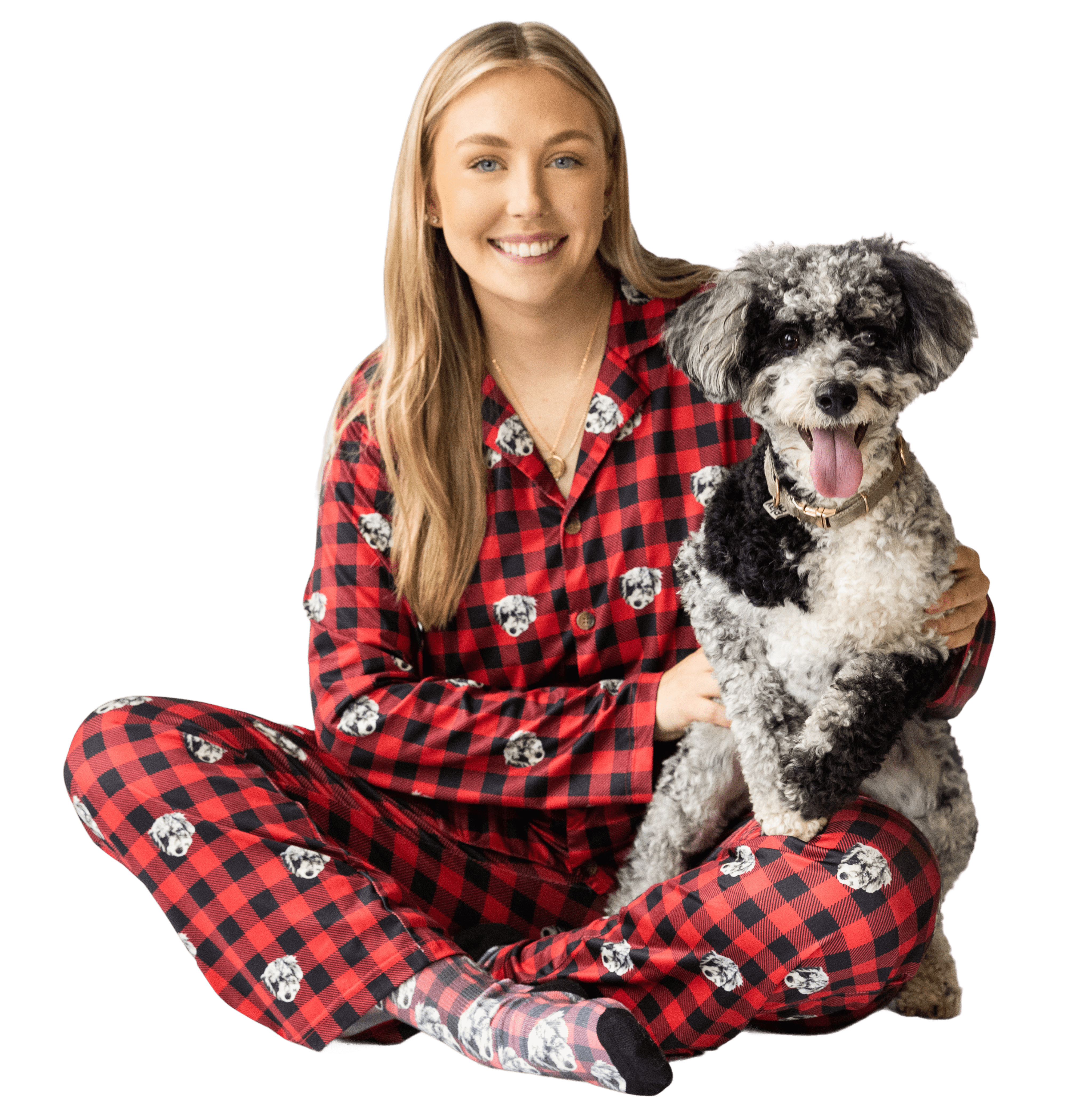 Woman in red plaid pajamas with a smiling black and white dog.