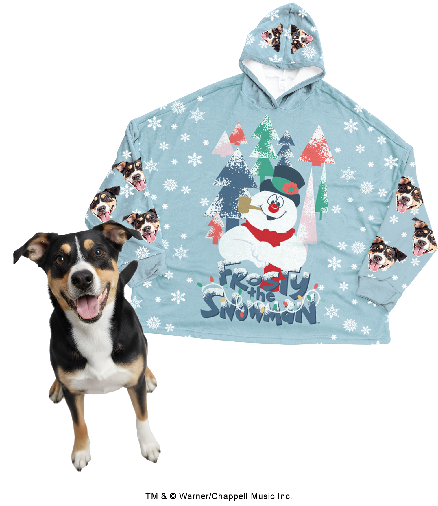 An oversized, light blue hooded blanket patterned with white snowflakes. The center features a large graphic of Frosty the Snowman standing in a colorful forest, with the title 'Frosty the Snowman' written below. The sleeves and hood are patterned with a repeating design of a black, white, and tan dog's face. A real dog with matching markings stands happily in the foreground.