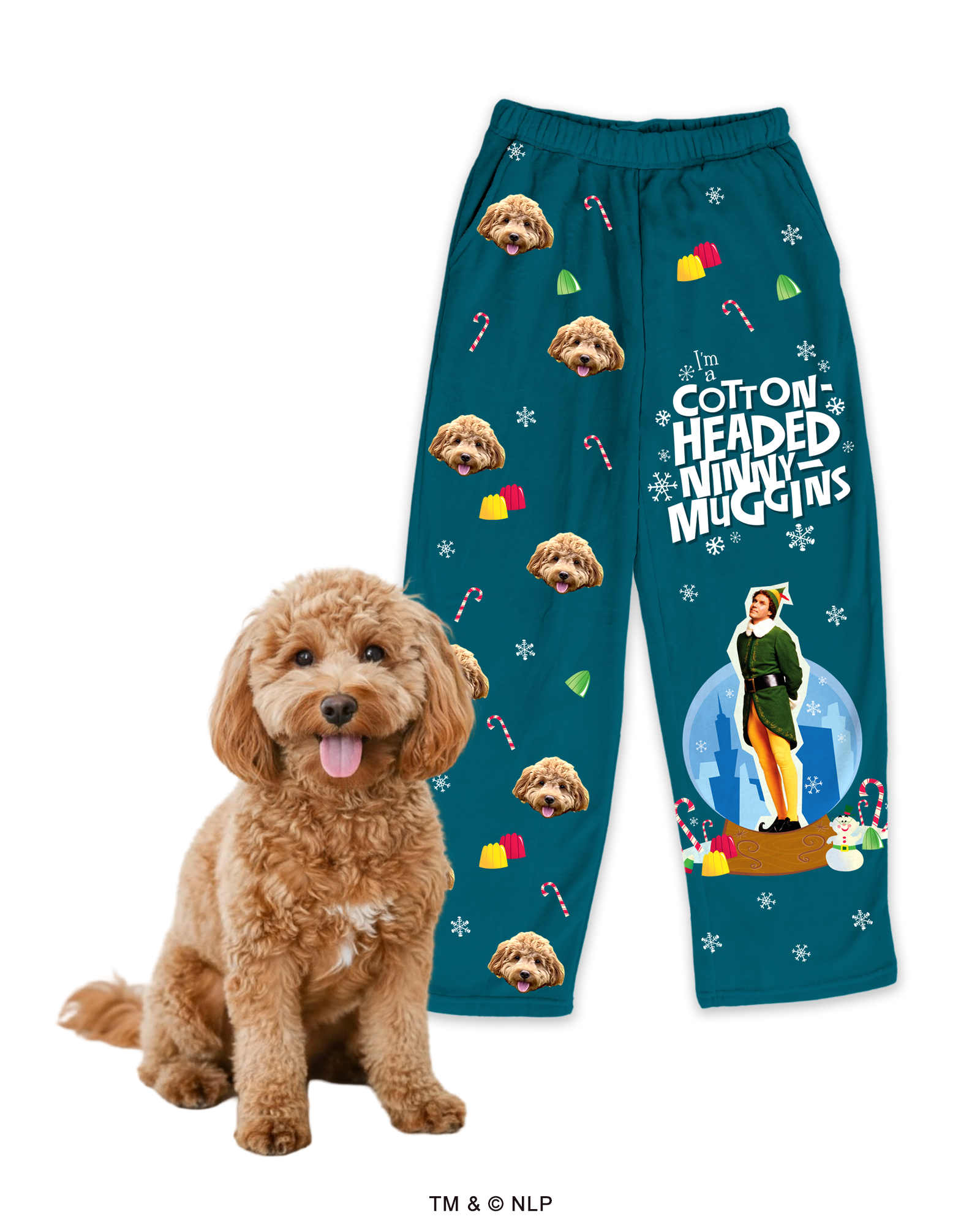 Teal pajama pants patterned with repeated images of a fluffy brown Cockapoo's head, candy canes, and candy. The left leg features a large graphic of Buddy the Elf in a snow globe scene and the quote 'I'm a cotton-headed ninny muggins.' A real Cockapoo sits next to the pants.