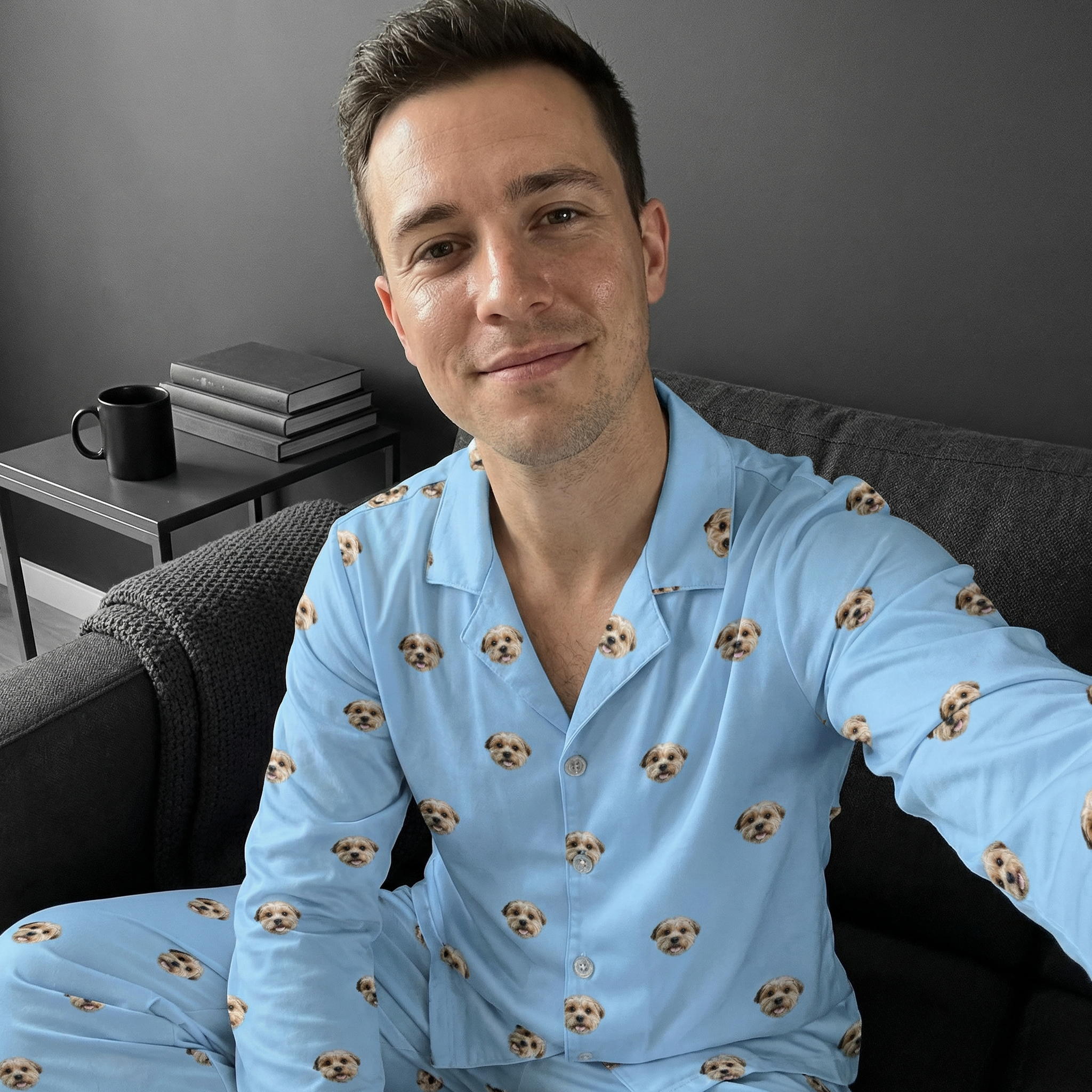 Smiling man on couch wearing light blue pajamas