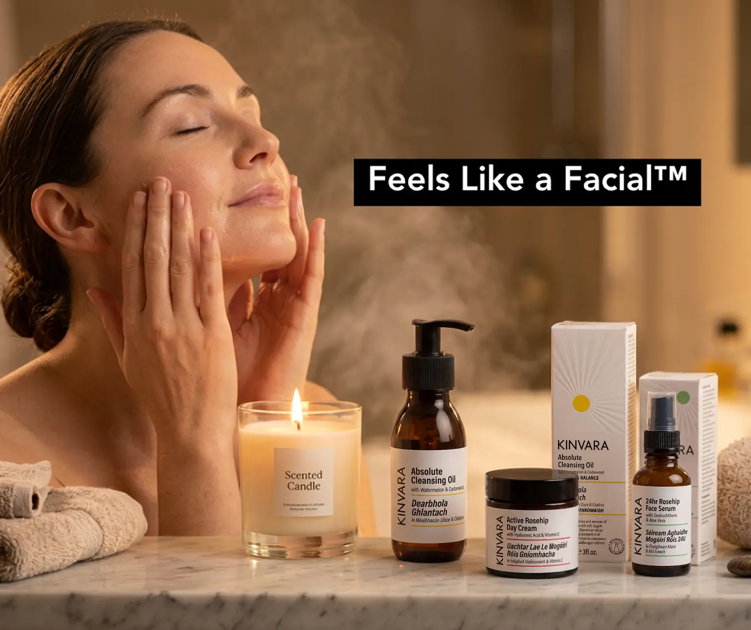 A woman with eyes closed applies facial products from Kinvara, surrounded by a candle and towels.