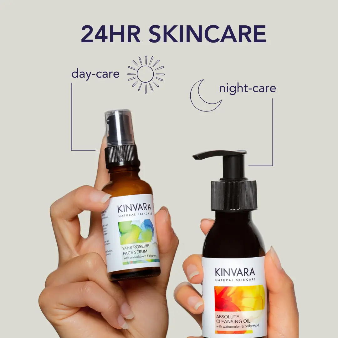 Two hands holding Kinvara skincare products for day and night care.