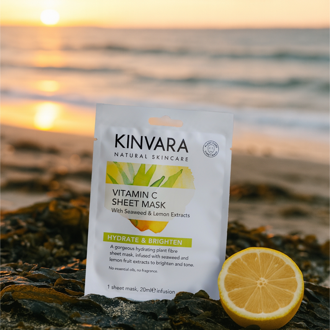 Kinvara Vitamin C sheet mask on a beach with a lemon and sunset in the background.