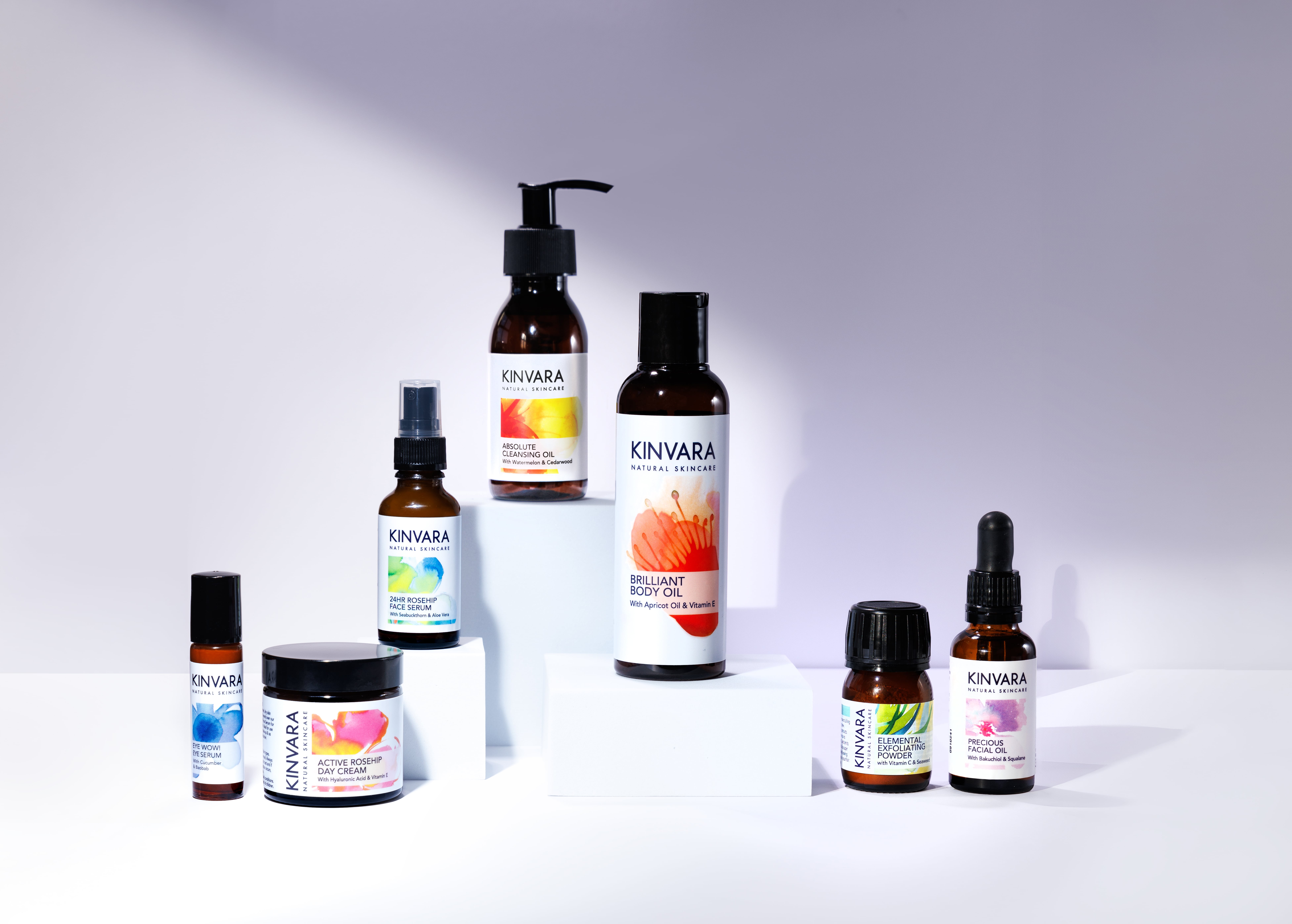 Assorted Kinvara skincare products arranged on white blocks.